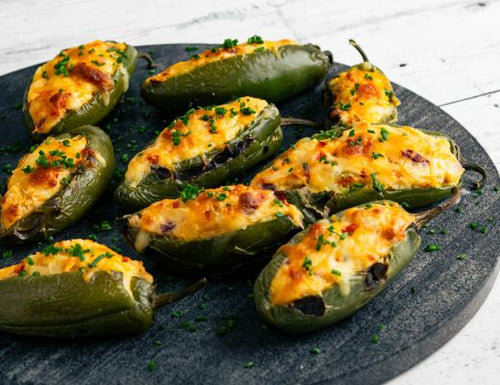 Dutch Potato Jalapeño Poppers filled with creamy mashed potatoes and melted cheese, baked until golden and garnished with fresh herbs on a serving platter