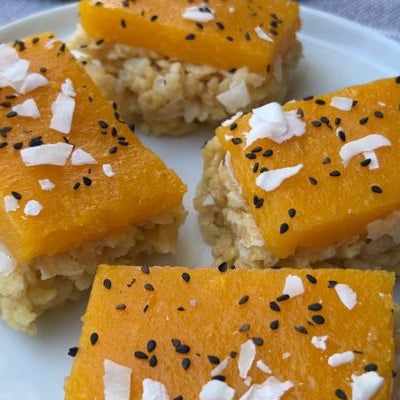 Mango Sticky Rice Crispy Treats featuring a coconut Rice Krispies base topped with fresh Tree Ripened Mango gelatin, finished with toasted coconut flakes and black sesame seeds for a tropical no-bake dessert.