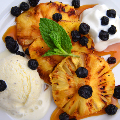 Image of Grilled Pineapple with Vanilla Bean Ice Cream, Dried Blueberries and Caramel Sauce
