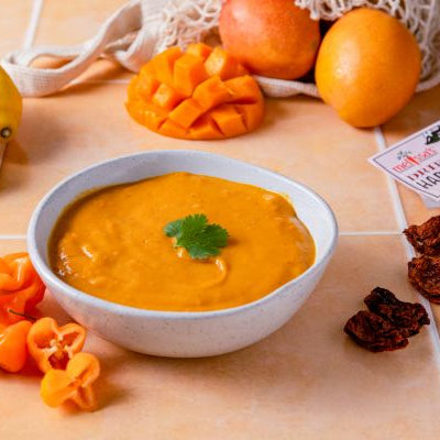 Bowl of Mango-Habanero Sauce with garnish on a wooden surface with ingredients around