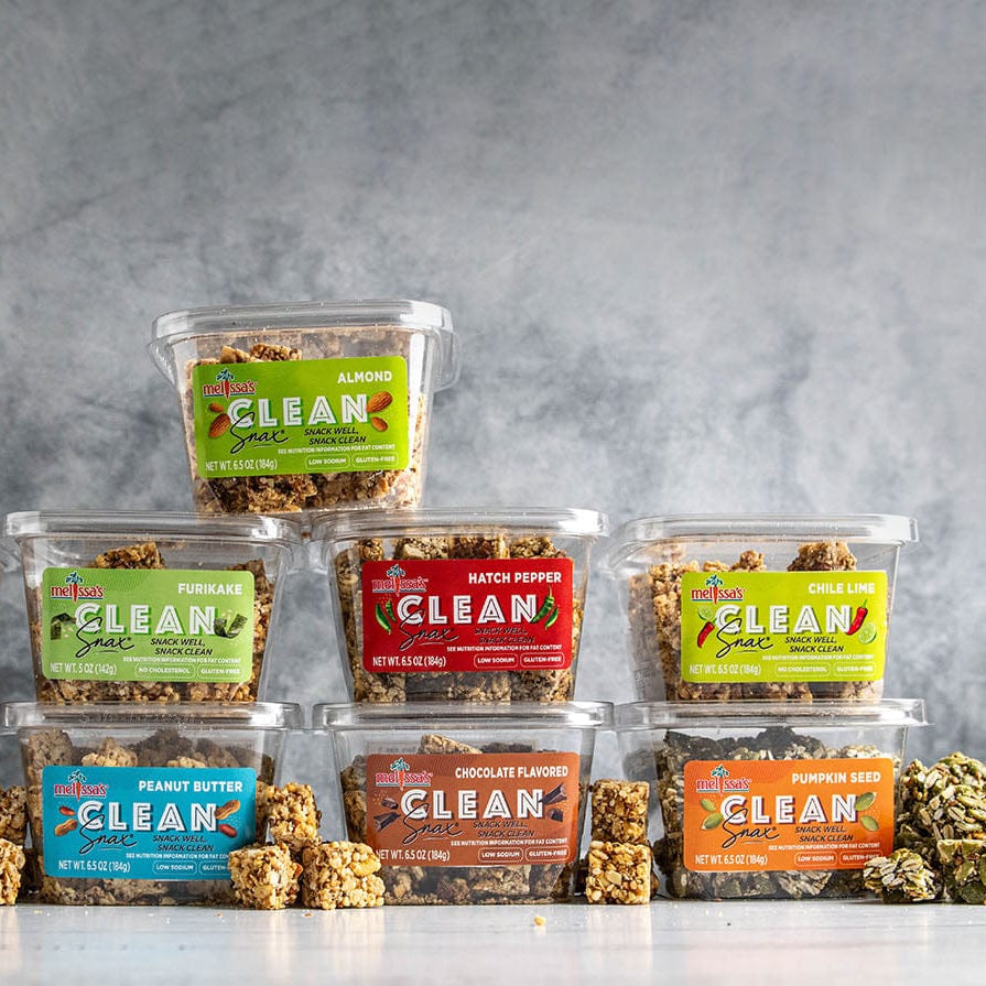 Assorted containers of 'CLEAN Snax' brand snacks on a gray background