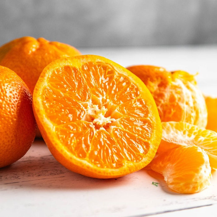 Nadorcott Mandarins sliced and on a wooden surface
