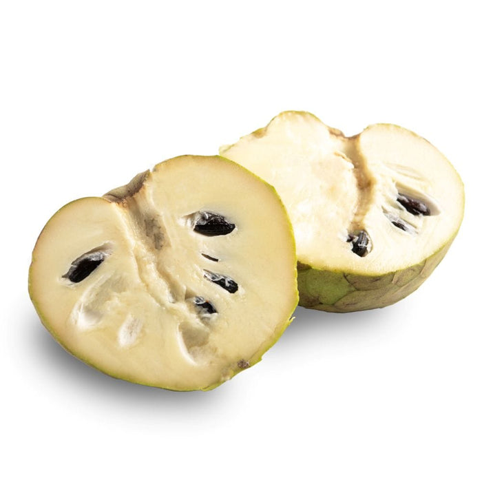 Organic Cherimoy cut in half on a white surface.